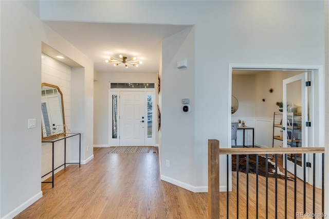 foyer with light wood-type flooring and an inviting chandelier