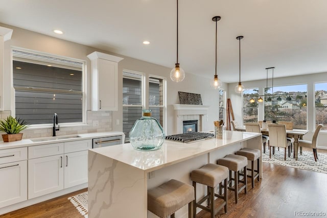 kitchen with white cabinets, backsplash, sink, and a kitchen island