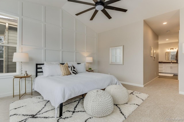 carpeted bedroom with ceiling fan, lofted ceiling, and connected bathroom