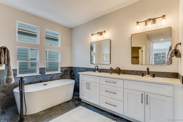 bathroom with tile walls, a tub to relax in, and vanity