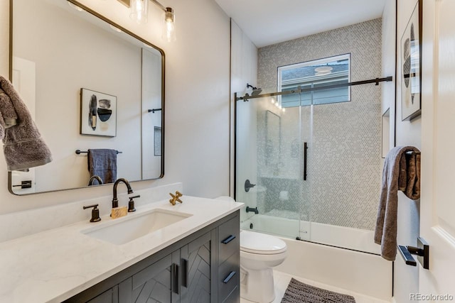 full bathroom with toilet, vanity, and shower / bath combination with glass door