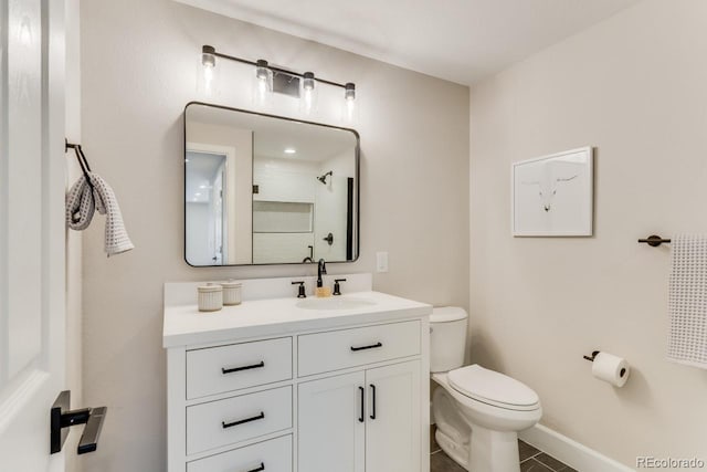 bathroom featuring toilet, vanity, and tile patterned flooring