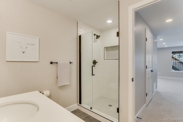 bathroom with an enclosed shower and sink