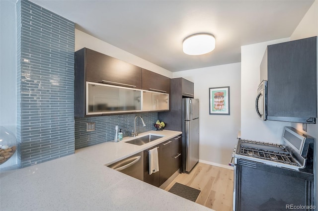 kitchen with stainless steel appliances, light hardwood / wood-style flooring, backsplash, and sink