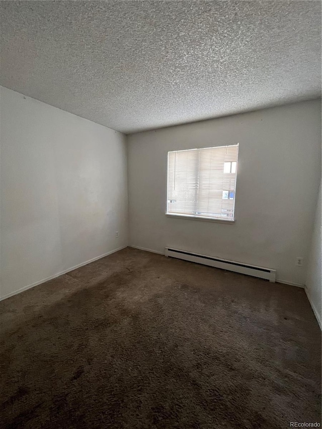 unfurnished room with a baseboard radiator, a textured ceiling, and dark carpet