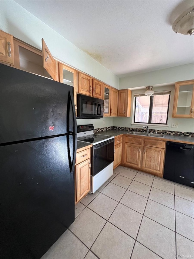 3658 S Norfolk Way, Aurora, CO 80013 - kitchen with black appliances, dark countertops, light tile patterned floors, and glass insert cabinets