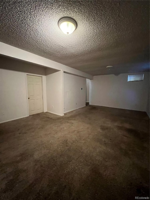 basement featuring carpet and a textured ceiling