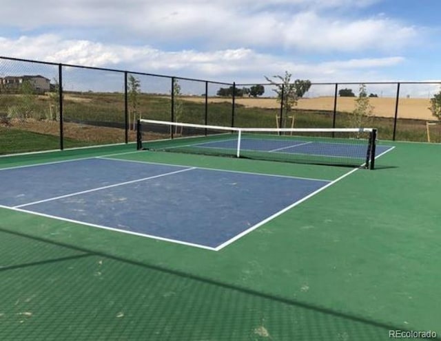 view of tennis court featuring fence