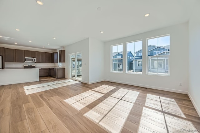 unfurnished living room with light wood finished floors and recessed lighting