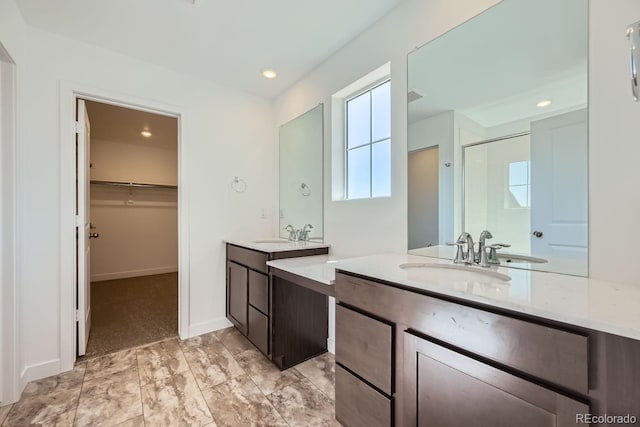 full bath with recessed lighting, a spacious closet, a shower stall, vanity, and baseboards