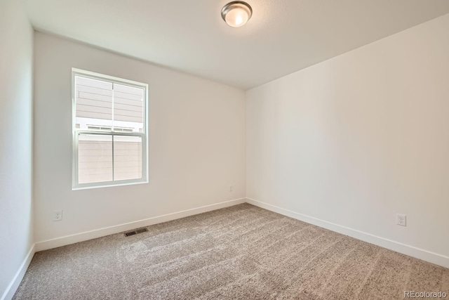 carpeted empty room featuring visible vents and baseboards