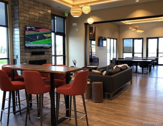 bar with a fireplace and wood finished floors