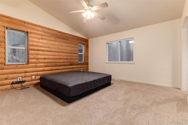 carpeted bedroom featuring ceiling fan, lofted ceiling, and rustic walls