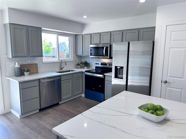 4382 S Xenon St, Morrison, CO 80465 - kitchen with appliances with stainless steel finishes, gray cabinets, wood finished floors, light stone counters, and recessed lighting