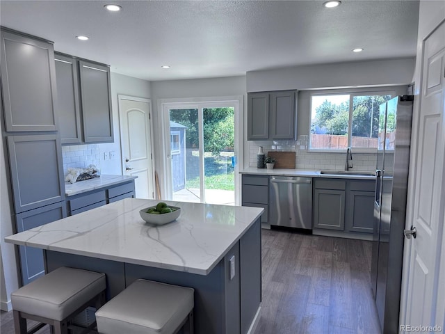 4382 S Xenon St, Morrison, CO 80465 - kitchen featuring appliances with stainless steel finishes, gray cabinetry, dark wood-style flooring, recessed lighting, and decorative backsplash