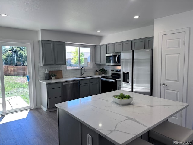 4382 S Xenon St, Morrison, CO 80465 - kitchen with stainless steel appliances, gray cabinets, wood finished floors, backsplash, and light stone counters