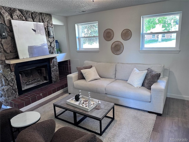 4382 S Xenon St, Morrison, CO 80465 - living room with wood finished floors, a textured ceiling, and a fireplace