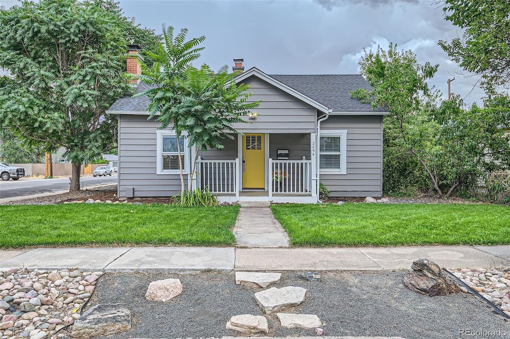 view of front facade featuring covered porch and a front lawn