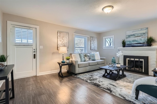 living room featuring a fireplace, dark hardwood / wood-style floors, and a textured ceiling