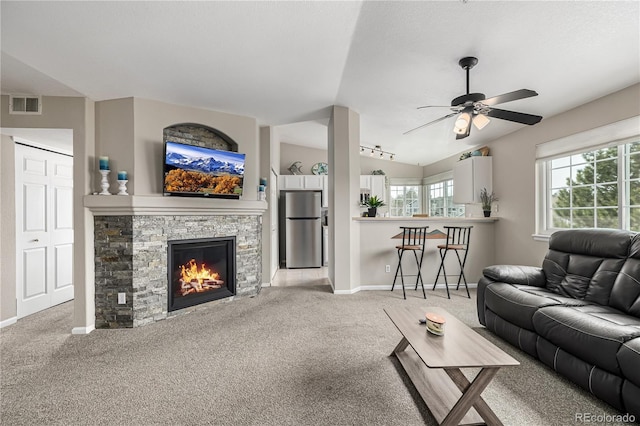 6840 Xavier Cir Unit 5, Westminster, CO 80030 - living area with light colored carpet, a ceiling fan, baseboards, a fireplace, and vaulted ceiling