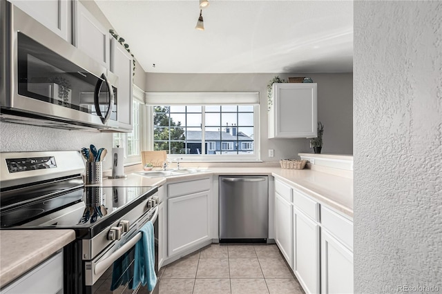 6840 Xavier Cir Unit 5, Westminster, CO 80030 - kitchen with appliances with stainless steel finishes, a sink, light countertops, white cabinetry, and a textured wall
