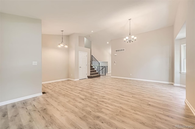 2552 E 126th Way, Thornton, CO 80241 - unfurnished living room featuring a chandelier, lofted ceiling, light wood-style floors, stairway, and baseboards