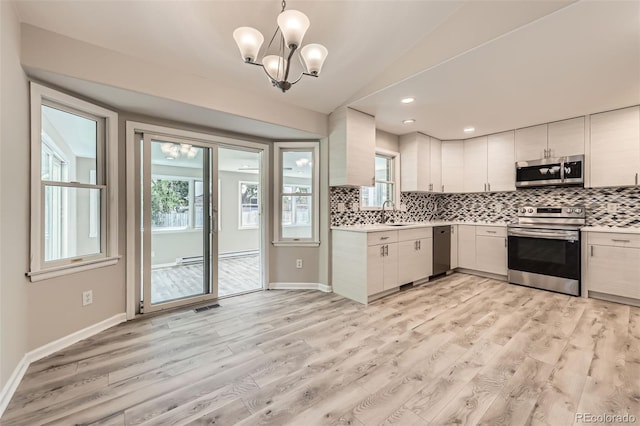 2552 E 126th Way, Thornton, CO 80241 - kitchen featuring appliances with stainless steel finishes, light countertops, light wood finished floors, tasteful backsplash, and healthy amount of natural light