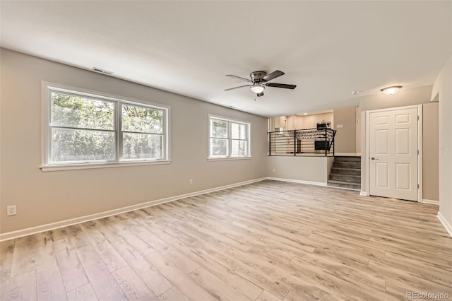 2552 E 126th Way, Thornton, CO 80241 - unfurnished living room with light wood-style flooring, a ceiling fan, baseboards, and stairs