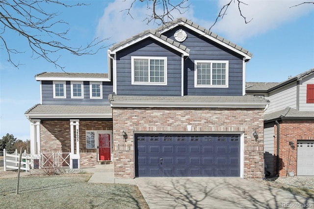 craftsman house with brick siding, fence, concrete driveway, a tile roof, and an attached garage