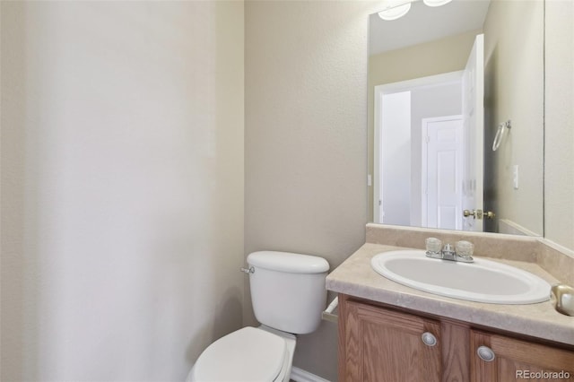 half bath featuring toilet and vanity