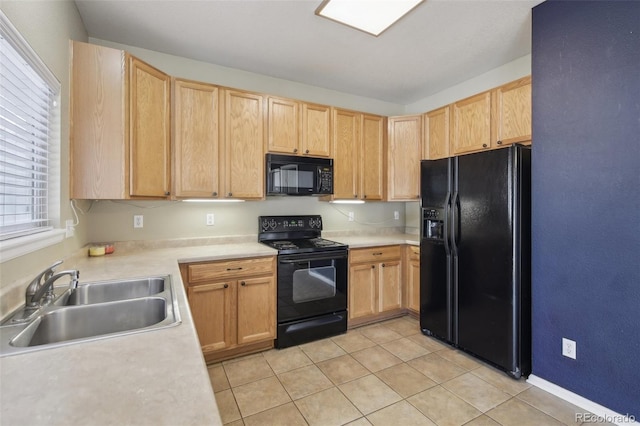 kitchen with light tile patterned flooring, light brown cabinetry, a sink, black appliances, and light countertops