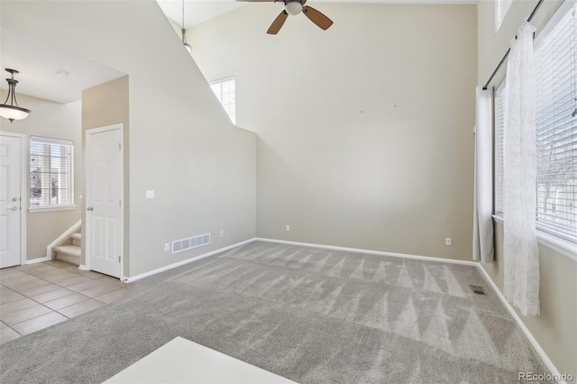 unfurnished living room featuring carpet flooring, visible vents, and a wealth of natural light