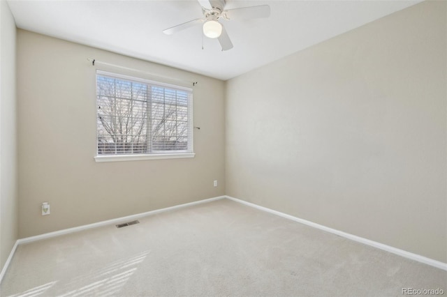 spare room featuring a ceiling fan, baseboards, visible vents, and carpet floors