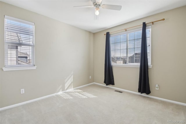 unfurnished room featuring a ceiling fan, visible vents, carpet floors, and baseboards