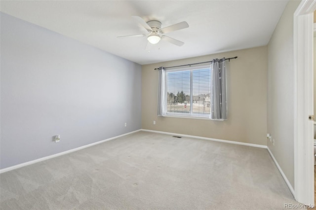 spare room featuring baseboards, carpet floors, visible vents, and ceiling fan