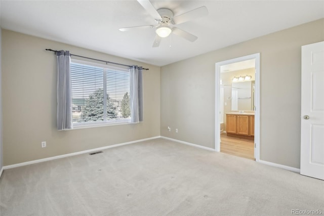 unfurnished bedroom featuring visible vents, a ceiling fan, ensuite bath, baseboards, and light colored carpet