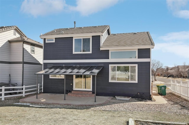 rear view of property featuring a standing seam roof, entry steps, fence, metal roof, and a patio area