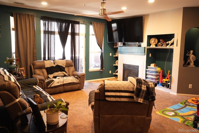 carpeted living room featuring baseboards, arched walkways, a ceiling fan, a fireplace, and recessed lighting