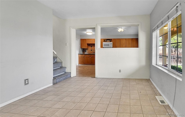 6671 Grove St, Denver, CO 80221 - unfurnished room featuring a ceiling fan, stairway, light tile patterned flooring, and baseboards