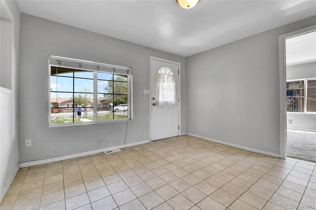 6671 Grove St, Denver, CO 80221 - foyer entrance featuring light tile patterned floors and baseboards