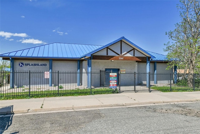 6671 Grove St, Denver, CO 80221 - view of front of house featuring a standing seam roof, metal roof, and a fenced front yard