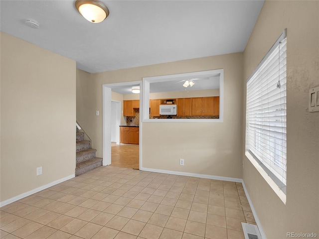 6671 Grove St, Denver, CO 80221 - unfurnished room featuring a smoke detector, light tile patterned floors, stairway, and ceiling fan