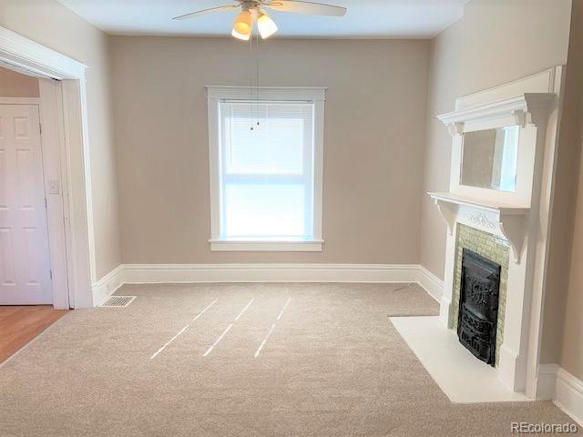 unfurnished living room with ceiling fan and light carpet