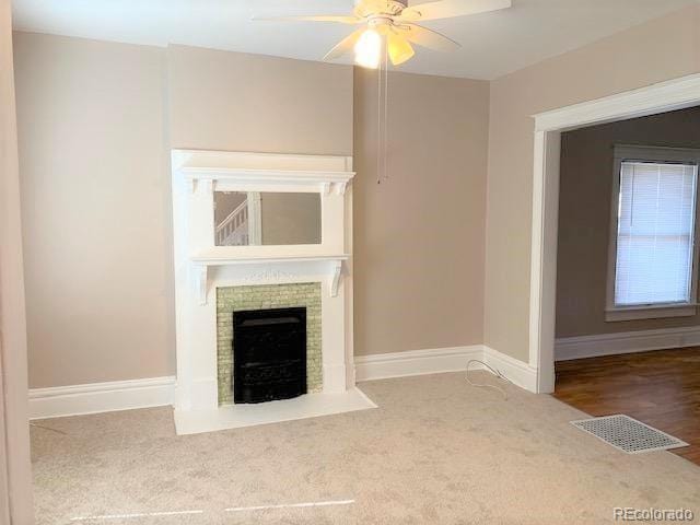 unfurnished living room featuring carpet flooring and ceiling fan