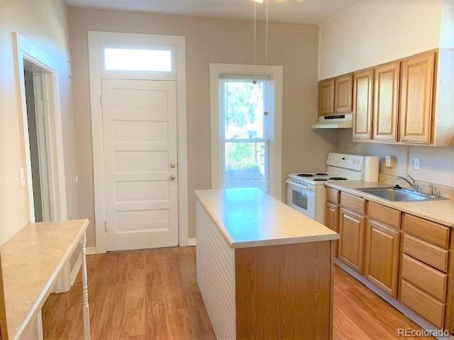 kitchen featuring a center island, sink, hanging light fixtures, electric range, and light hardwood / wood-style floors