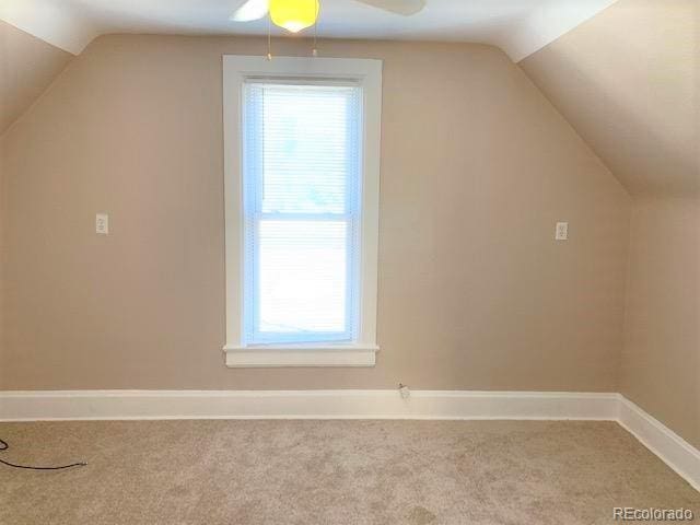 additional living space featuring ceiling fan, light carpet, and vaulted ceiling