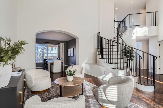 living room featuring a high ceiling, hardwood / wood-style floors, and a notable chandelier