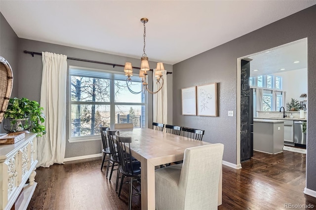 dining area featuring sink, dark hardwood / wood-style floors, and a chandelier