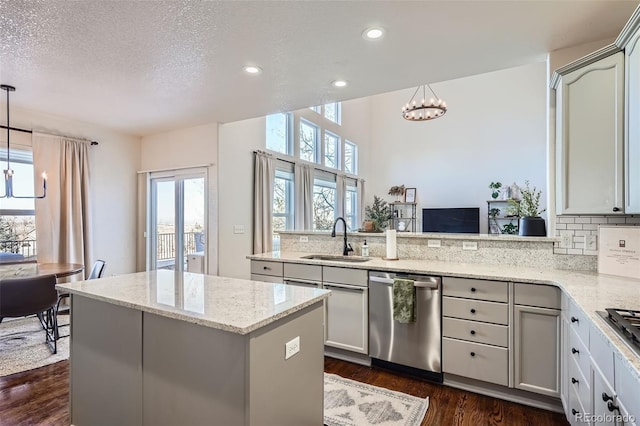 kitchen featuring sink, decorative light fixtures, a textured ceiling, dishwasher, and a chandelier