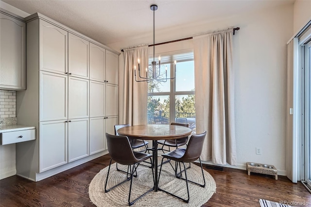 dining space with dark wood-type flooring and a chandelier